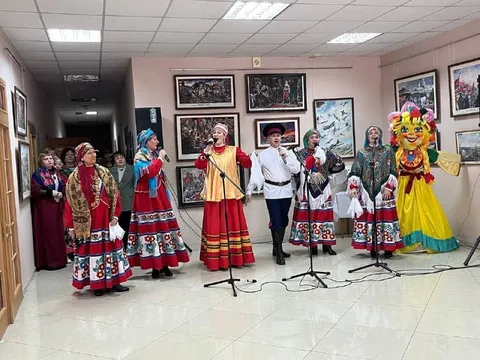 Вокальный ансамбль в народных костюмах поёт рядом с чучелом Масленицы