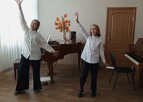 Две исполнительницы в белых рубашках на сцене