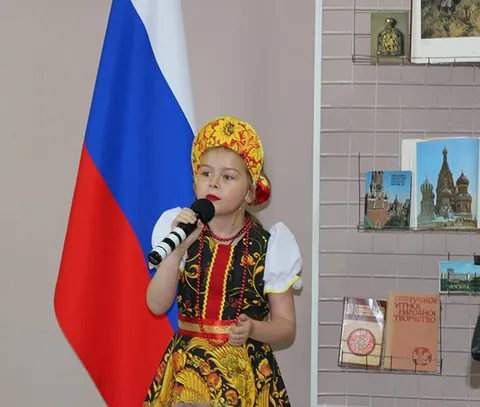 Девочка в народном костюме поёт у микрофона