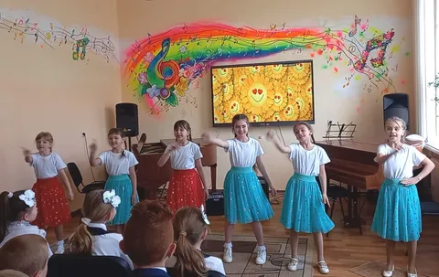 Девочки в бирюзовых юбках танцуют