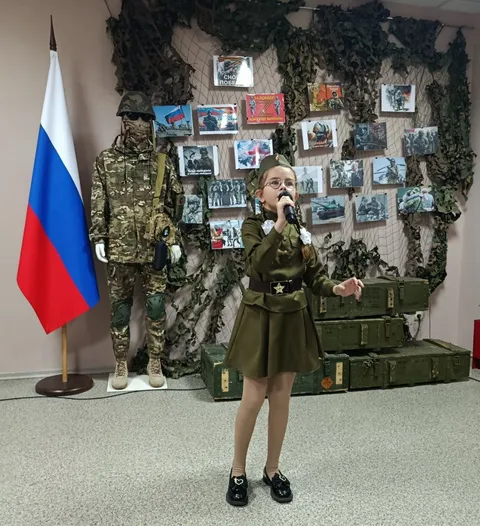 Юная солистка в гимнастёрке поёт