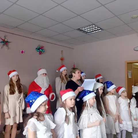 Дед Мороз и хор в новогодних колпаках