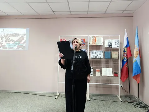 Ведущая читает текст у стенда выставки
